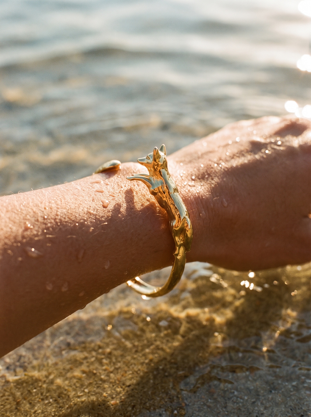 Brazalete Cuff Zorro Dorado en la muñeca entrando al agua | Buono Joyas