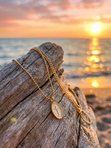 Cadena con Cruz sobre madera frente al mar al atardecer | Buono Joyas