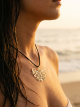 Collar Árbol de la Vida con dije dorado calado en el cuello, mar de fondo | Buono Joyas
