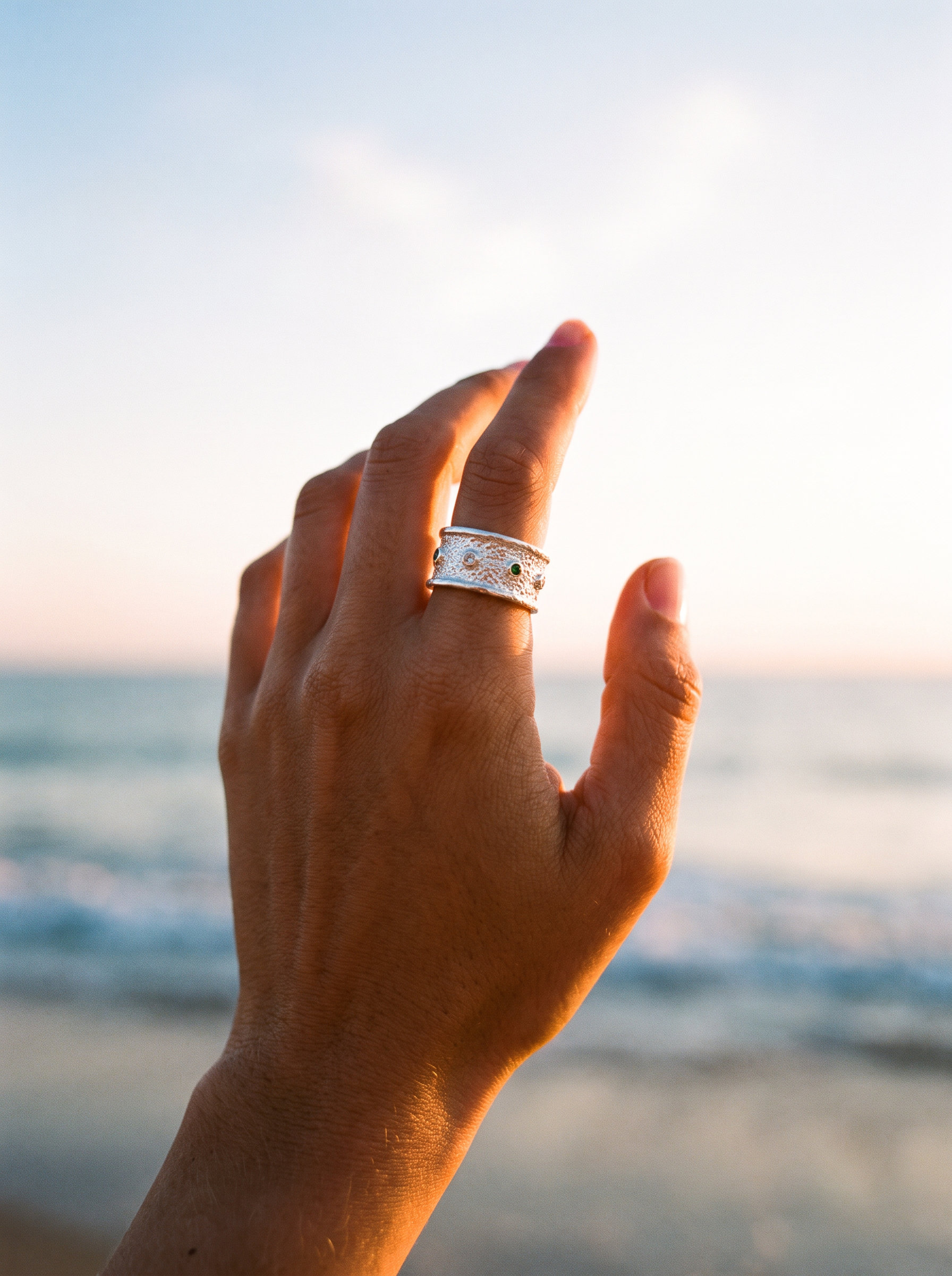 Anillo Polvo de Estrellas de plata, mano contra el cielo en la playa | Buono Joyas