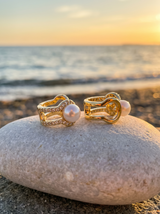Argollas Elegance sobre piedra de playa al atardecer | Buono Joyas