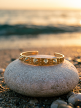 Brazalete Apex sobre piedra de playa al atardecer | Buono Joyas
