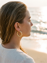 Argollas Perlas puestas en la oreja, playa al atardecer | Buono Joyas