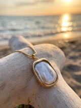 Collar Esencia con perla barroca sobre madera frente al mar | Buono Joyas