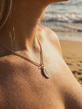 Cadena con San Benito en el escote, playa al atardecer | Buono Joyas