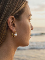 Argollas Elegance con perla en la oreja, playa al atardecer | Buono Joyas