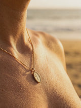 Cadena con Cruz dorada en el escote, playa al atardecer | Buono Joyas