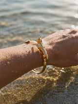 Brazalete Cuff Zorro Dorado en la muñeca entrando al agua | Buono Joyas